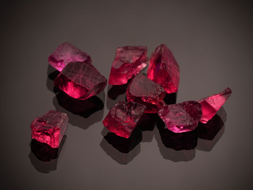 Rough red gemstones on a dark surface